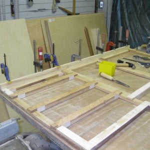 I glued plastic laminate in the corners for the drawers to glide on.  In this shot I am installing the kick to the face frame.
